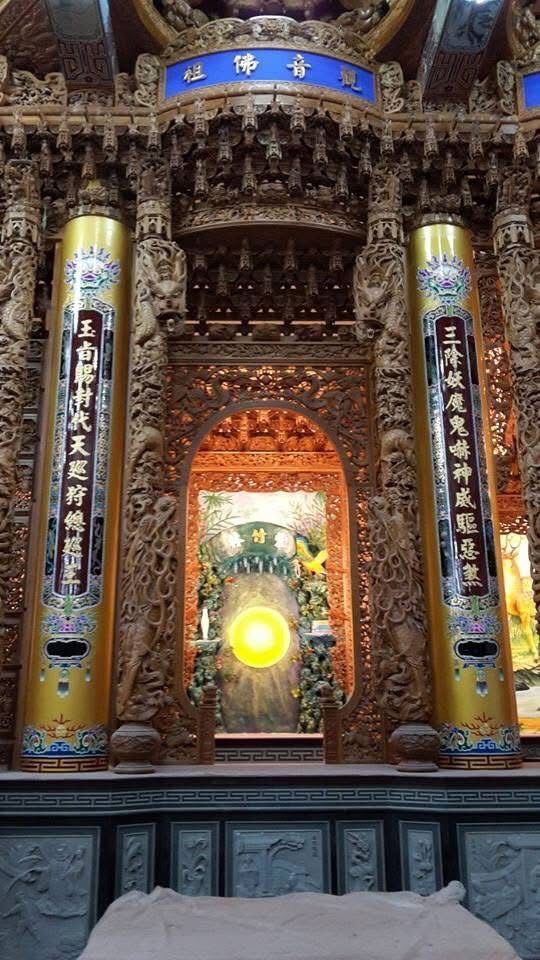 裝飾華麗的寺廟祭壇,配有雕刻精美的柱子、色彩繽紛的壁畫和熠熠生輝的中央燈光。