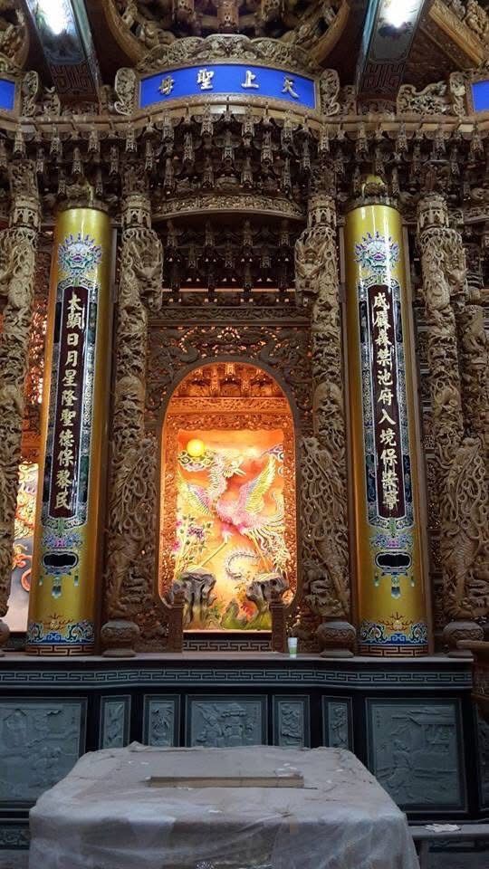 裝飾華麗的寺廟祭壇,有雕刻精美的柱子,中央神龕熠熠生輝,前面擺放著一張白色的供桌。