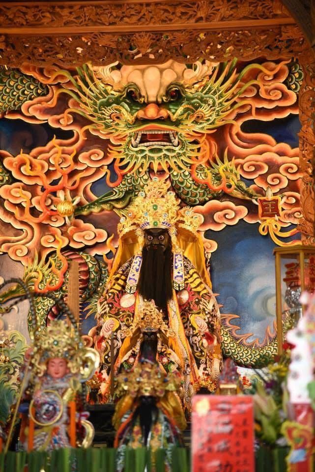 色彩繽紛的寺廟祭壇,飾以精美的龍紋雕刻和鮮花供品。