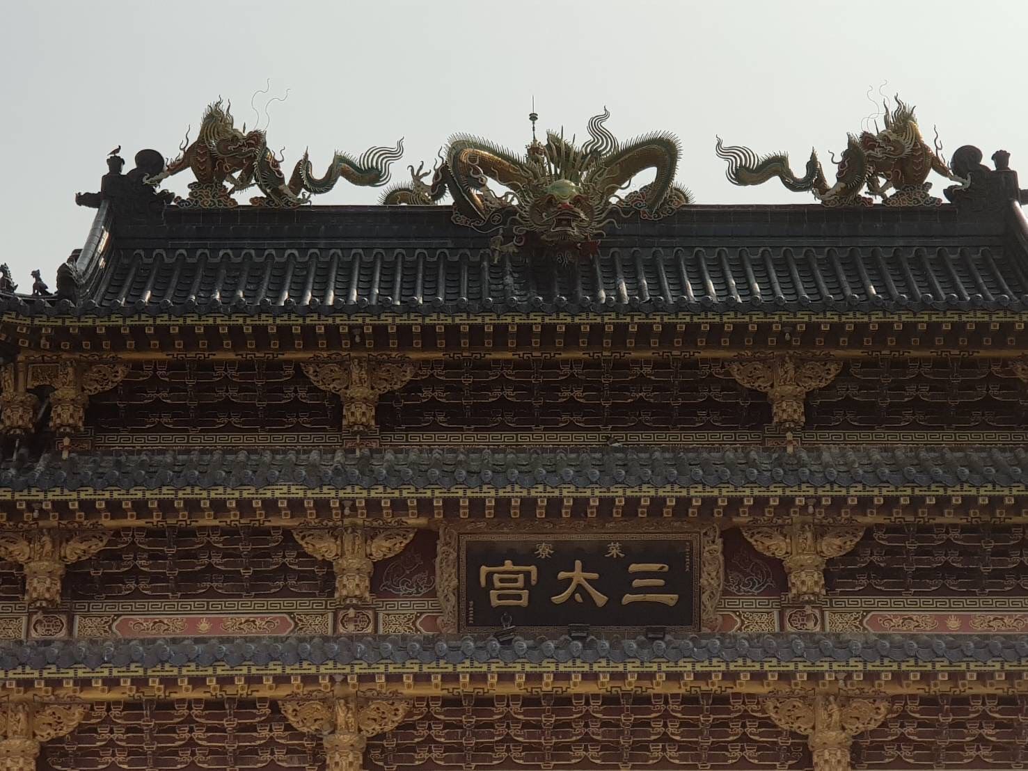 精美的中國寺廟屋頂,雕刻著龍的圖案,並掛有一塊寫著「泰大公」的牌匾。