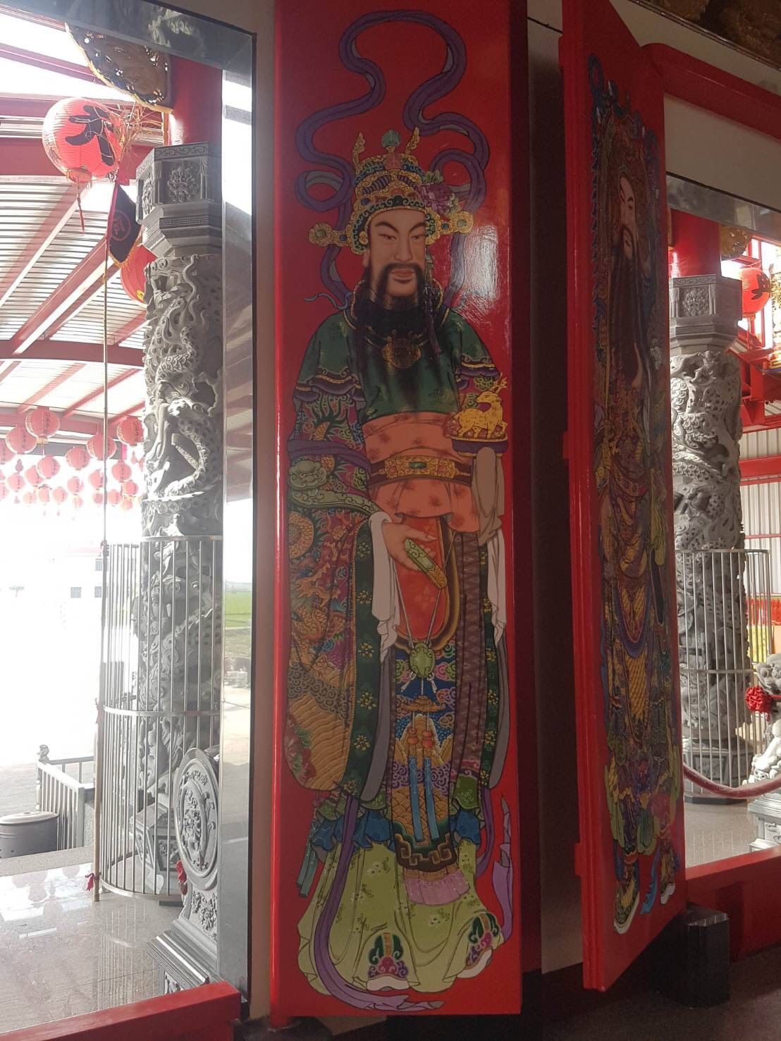 寺廟或神龕內紅色柱子上色彩鮮豔的中國守護神像壁畫。