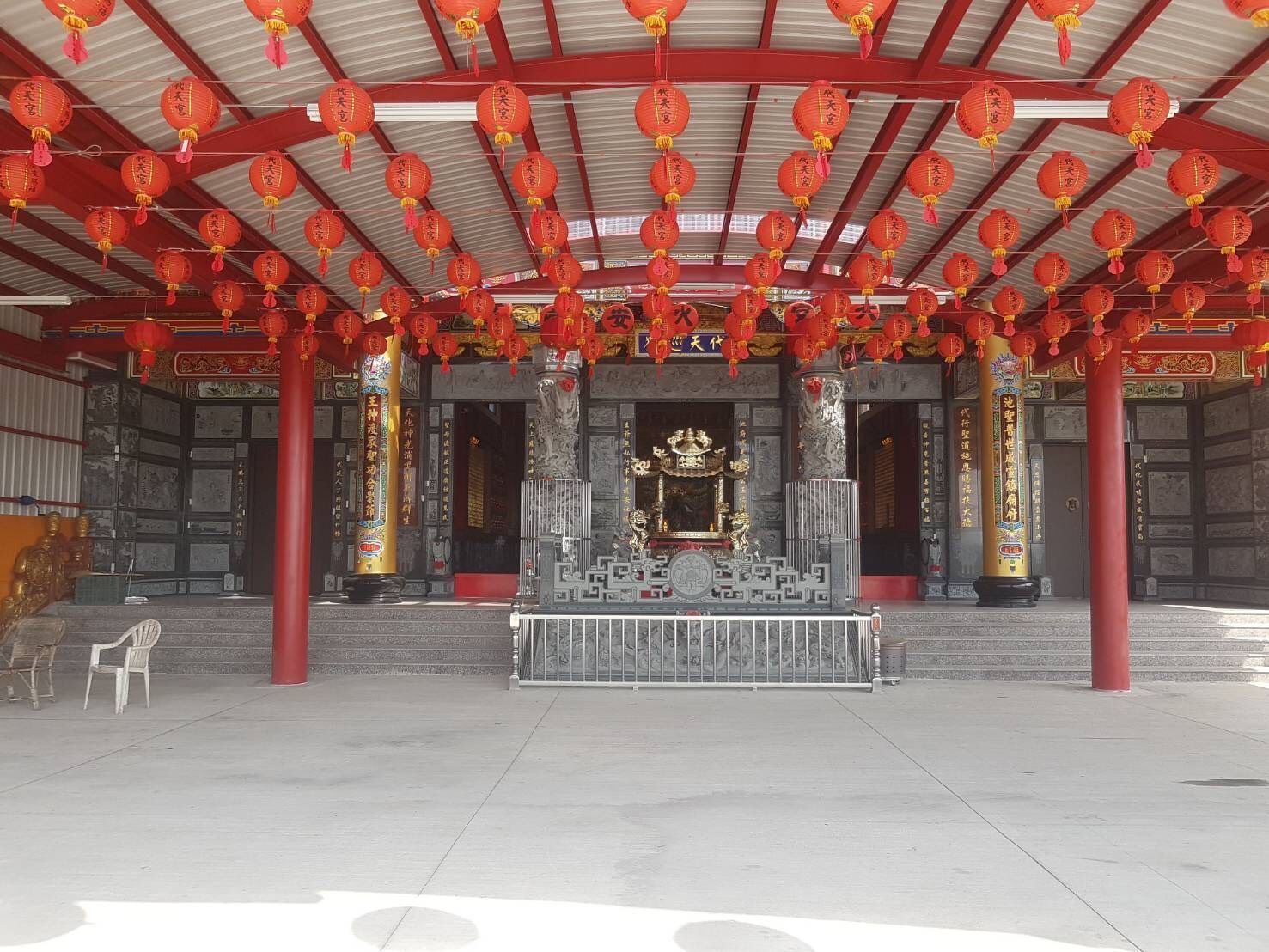 寺廟內部,天花板上懸掛著紅色燈籠,中央設有祭壇。