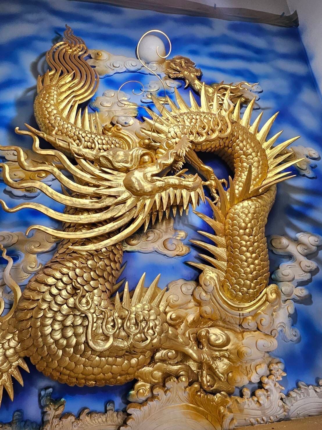 藍色背景上飾有金色巨龍浮雕,並點綴著旋渦狀雲紋。