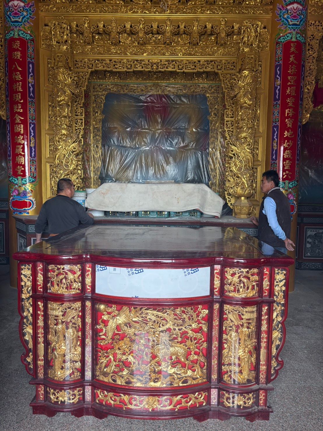 金色的祭壇,上面擺放著華麗的神龕,旁邊站著兩個人。