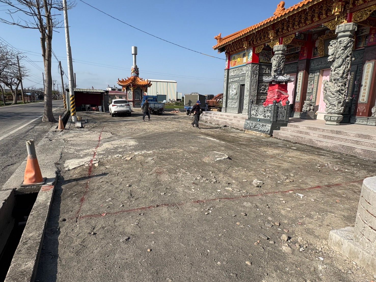 寺廟庭院,石砌建築,停放的車輛,以及湛藍的天空。