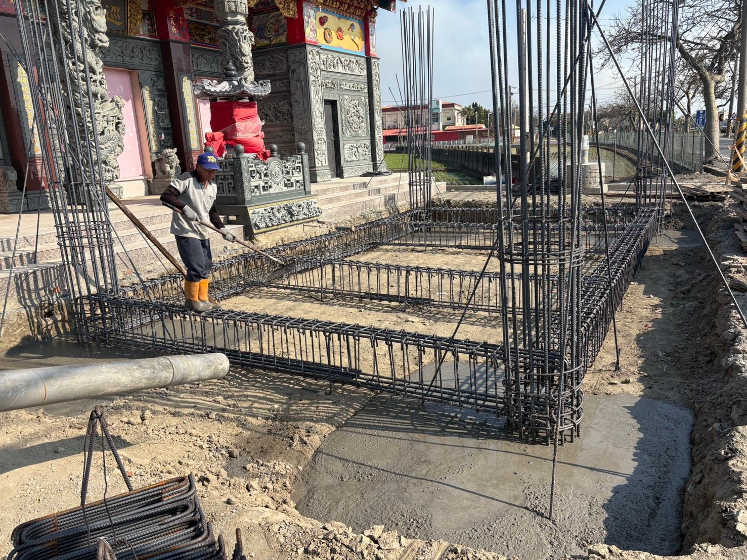 建築工地,鋼筋混凝土基礎,工人在混凝土建築旁作業。