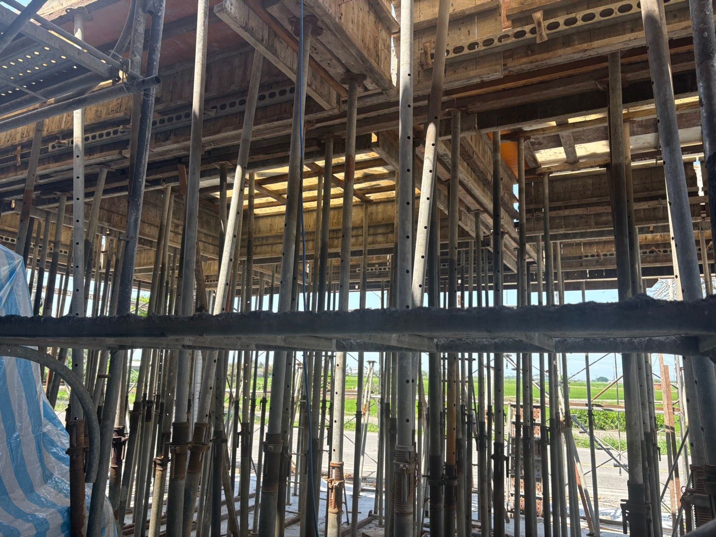 建築工地,裸露的鋼製鷹架和屋頂結構下的木框架清晰可見。