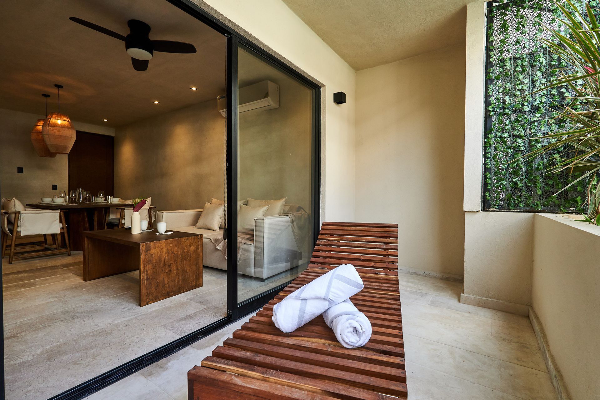 Un balcón con una silla de madera y toallas.