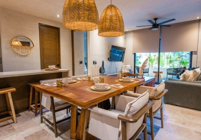 Un comedor con mesa y sillas de madera y ventilador de techo. Hotel Bakal Tulum
