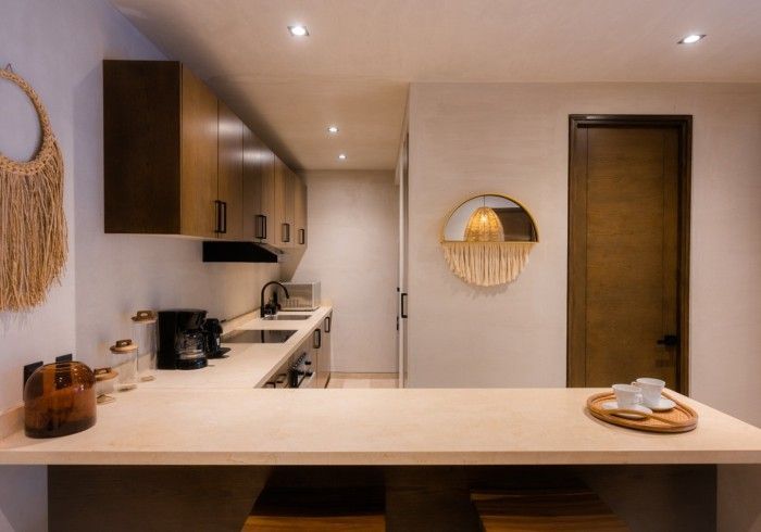 Una cocina con gabinetes de madera y encimera. Hotel Bakal Tulum