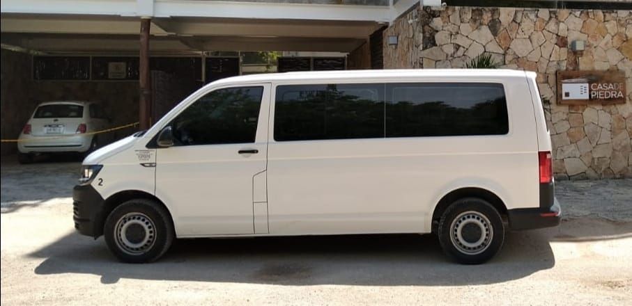 Una camioneta blanca está estacionada frente a un edificio.