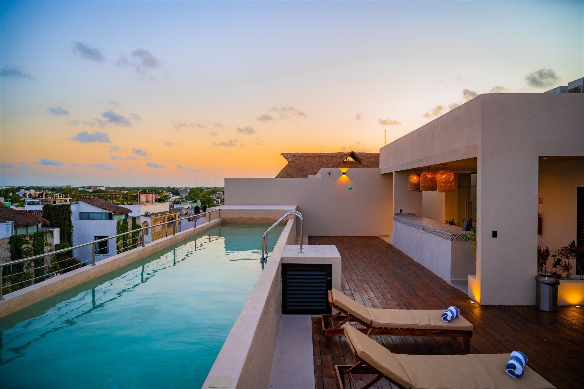 Hay una gran piscina en la azotea de un edificio. Hotel Bakal Tulum