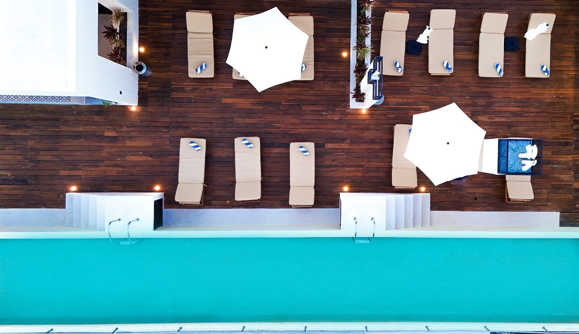 Una vista aérea de una piscina con sillas y sombrillas. Hotel Bakal Tulum