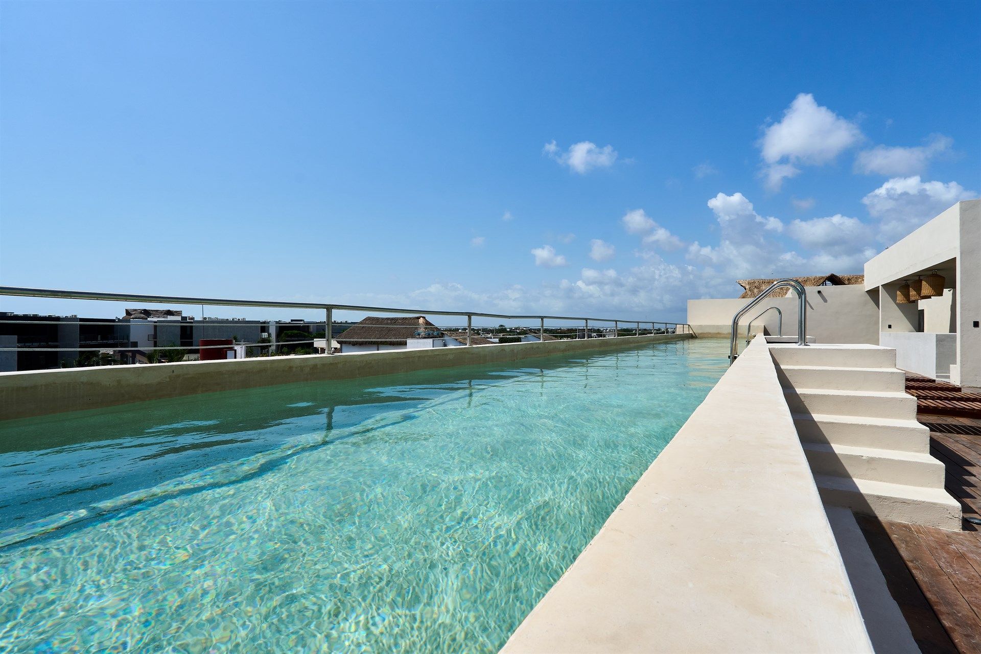 Hay una gran piscina en la azotea de un edificio. Hotel Bakal Tulum