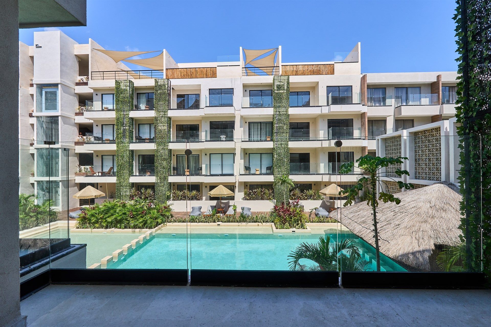 Un gran edificio con una piscina en frente. Hotel Bakal Tulum