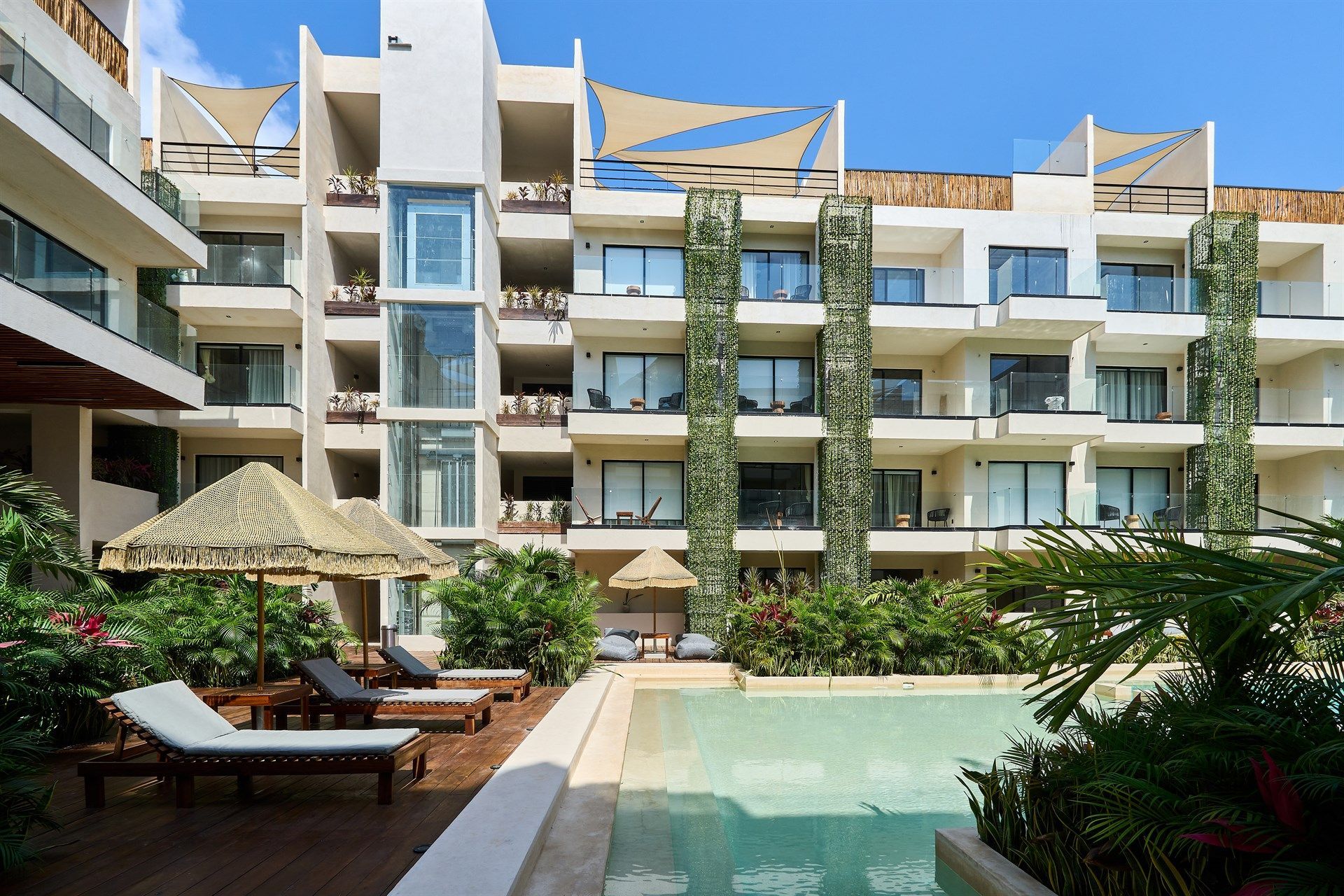 Un gran edificio con una piscina en frente. Hotel Bakal Tulum