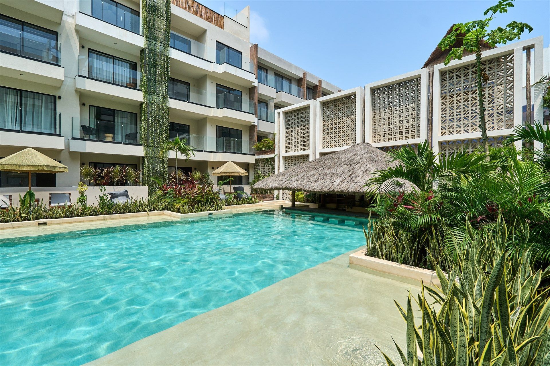 Una gran piscina frente a un hotel. Hotel Bakal Tulum
