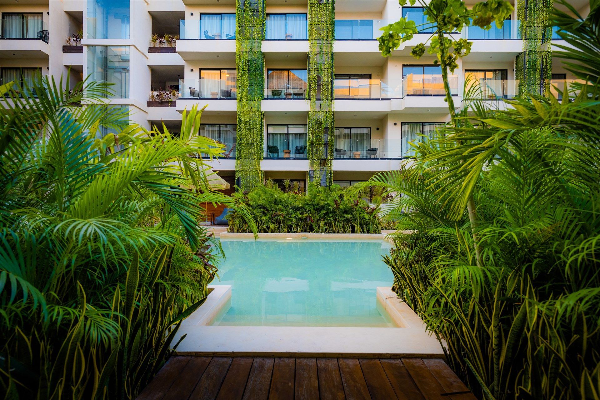 Hay una gran piscina en el medio de un edificio. Hotel Bakal Tulum