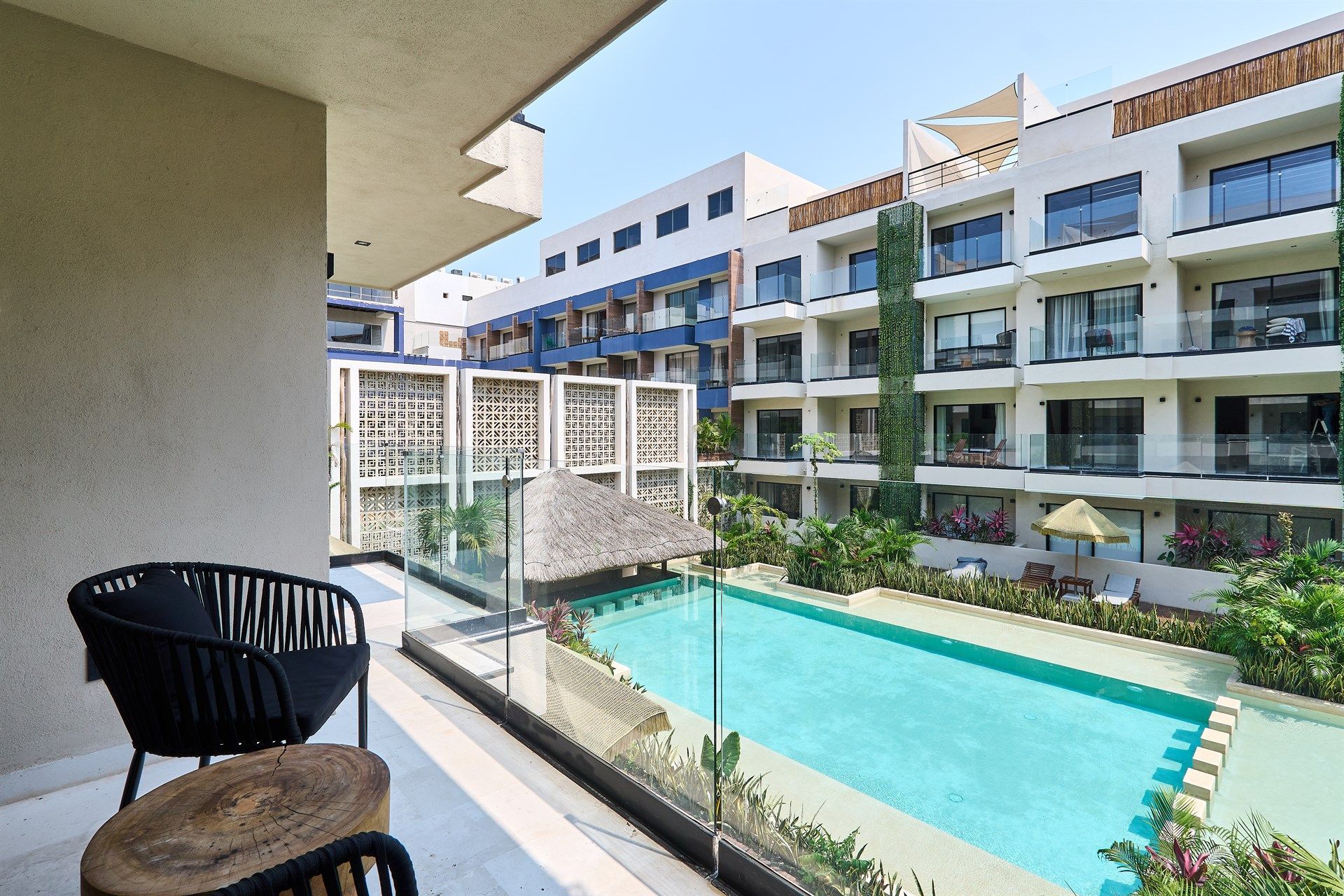 Un balcón con vista a una gran piscina. Hotel Bakal Tulum