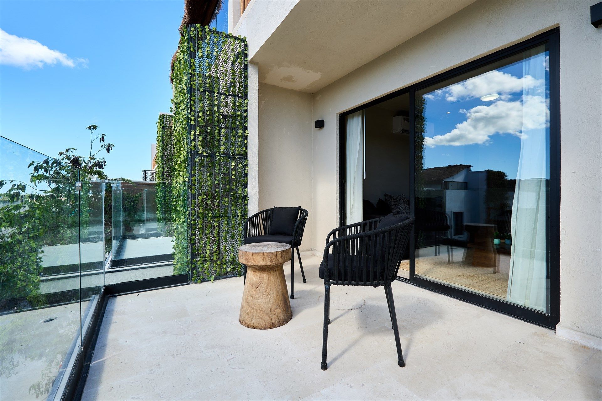 Hay dos sillas y una mesa en el balcón. Hotel Bakal Tulum