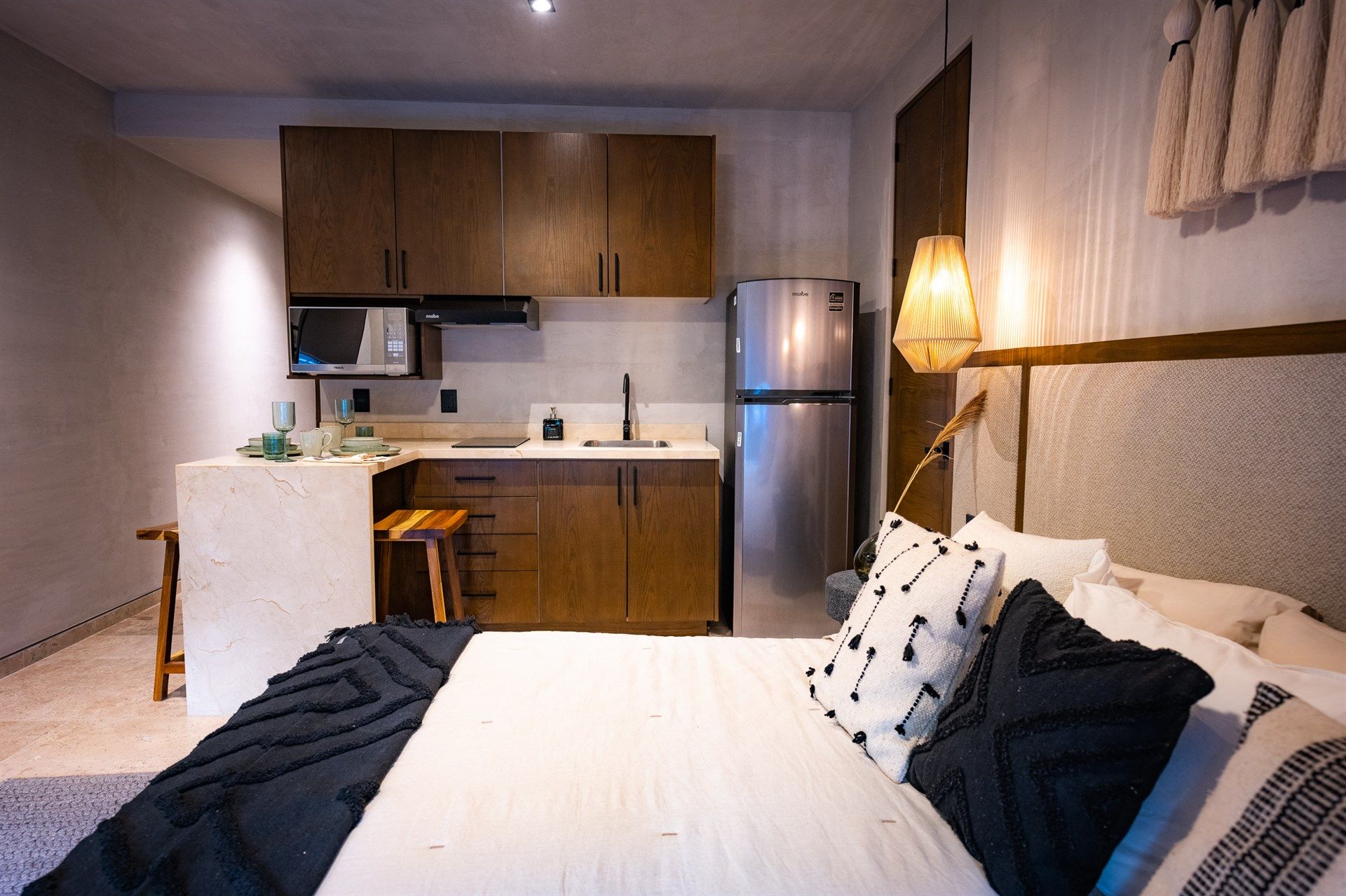 Un dormitorio con una cama y una cocina con nevera. Hotel Bakal Tulum