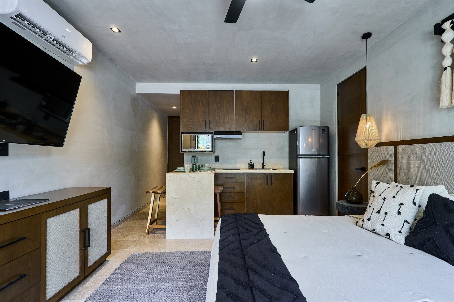 Un dormitorio con una cama king size y una cocina. Hotel Bakal Tulum