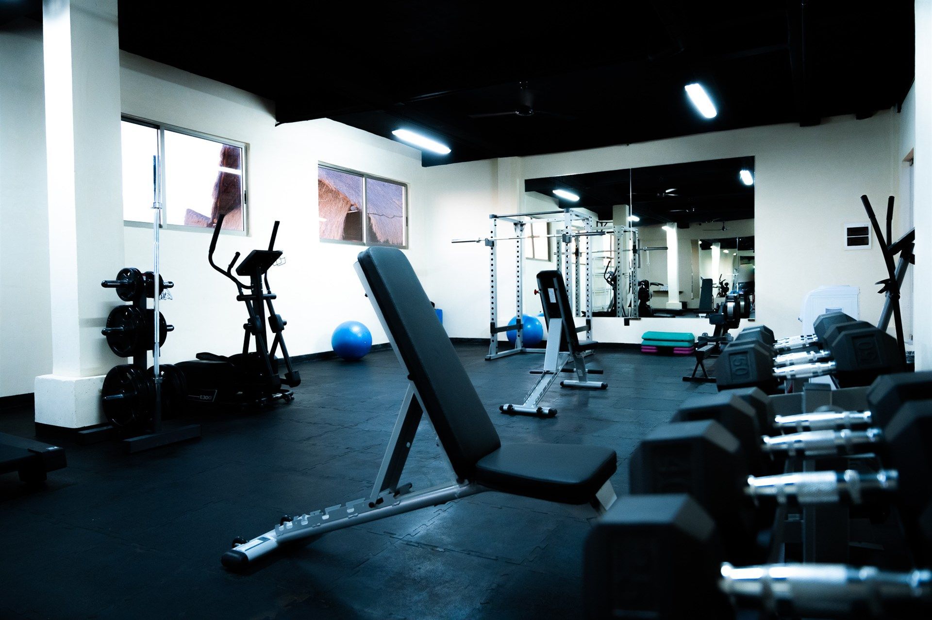 Un gimnasio con un banco y mancuernas.