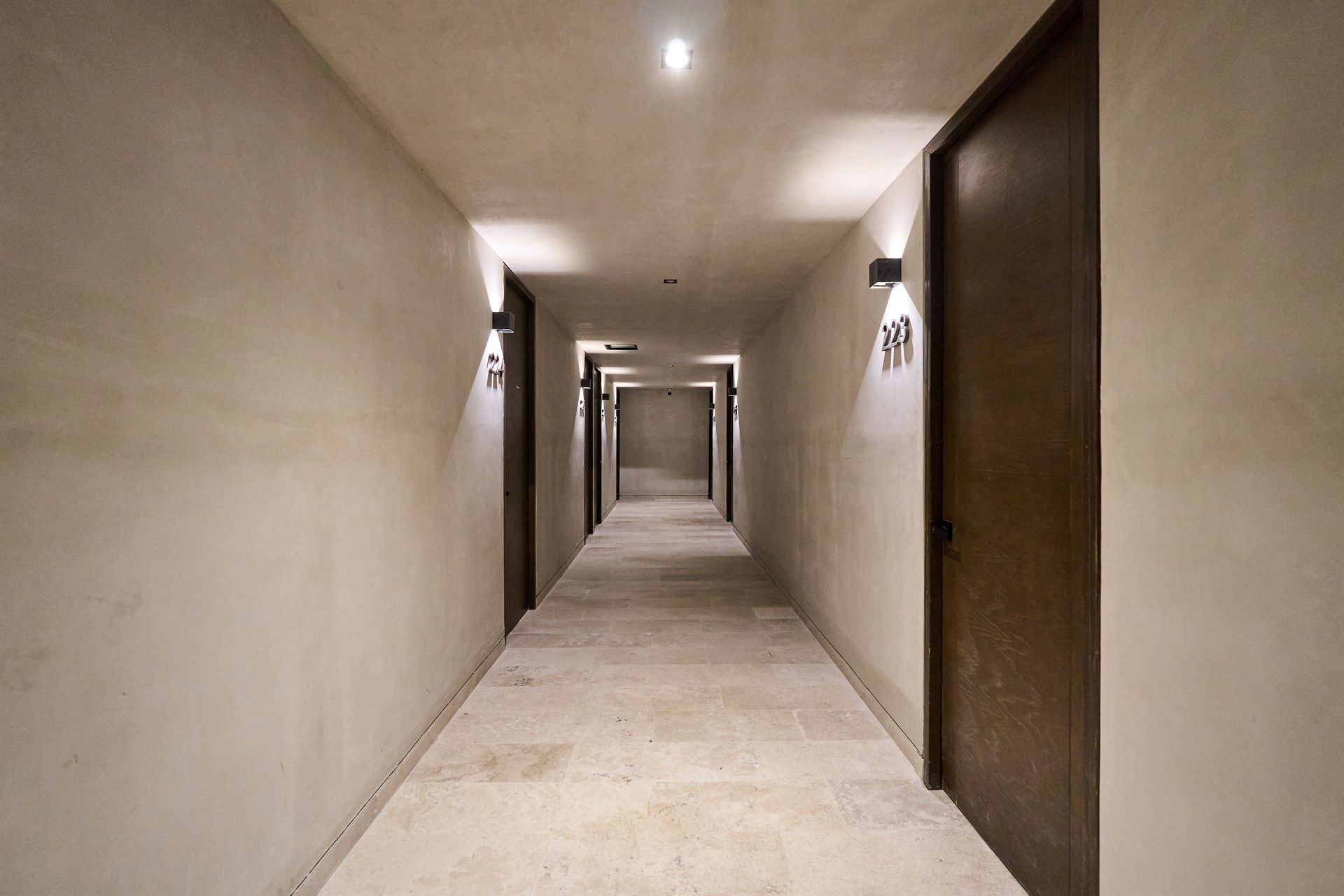 Un pasillo largo con muchas puertas en un edificio. Hotel Bakal Tulum