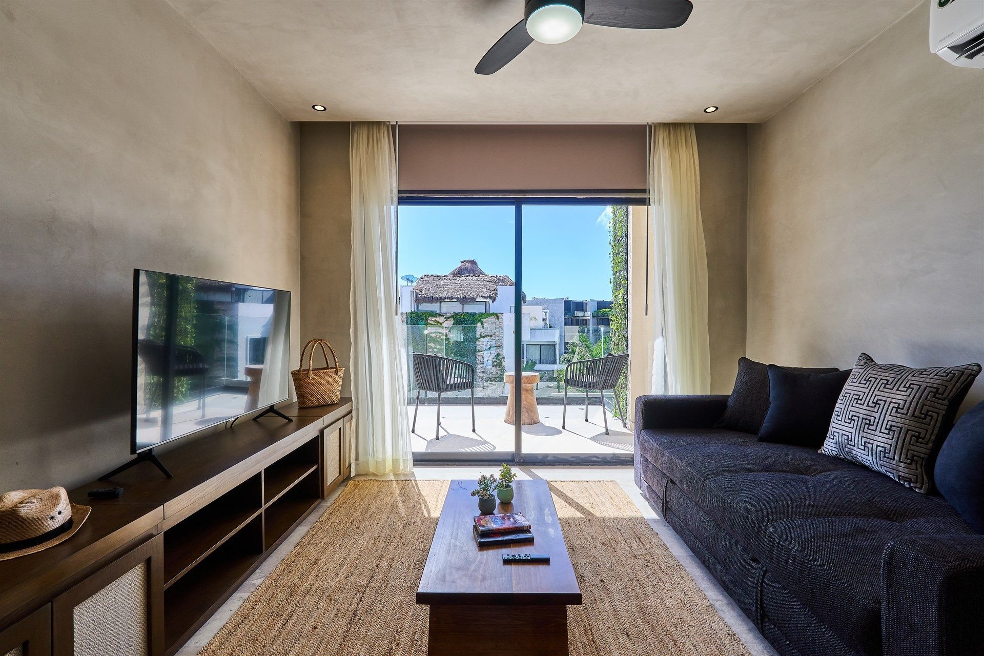 Una sala de estar con un sofá y un televisor de pantalla plana. Hotel Bakal Tulum