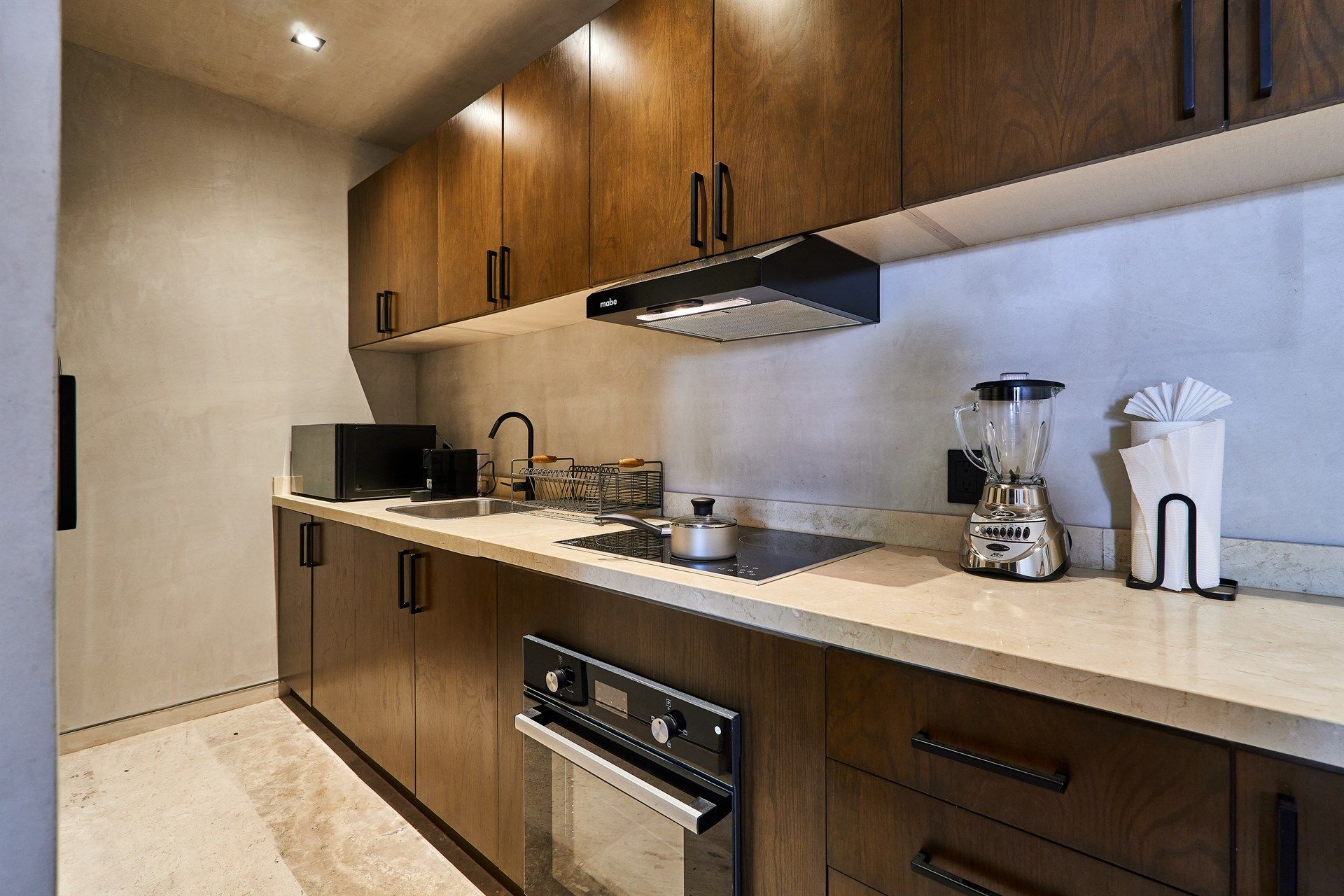 Una cocina con gabinetes de madera y electrodomésticos de acero inoxidable. Hotel Bakal Tulum