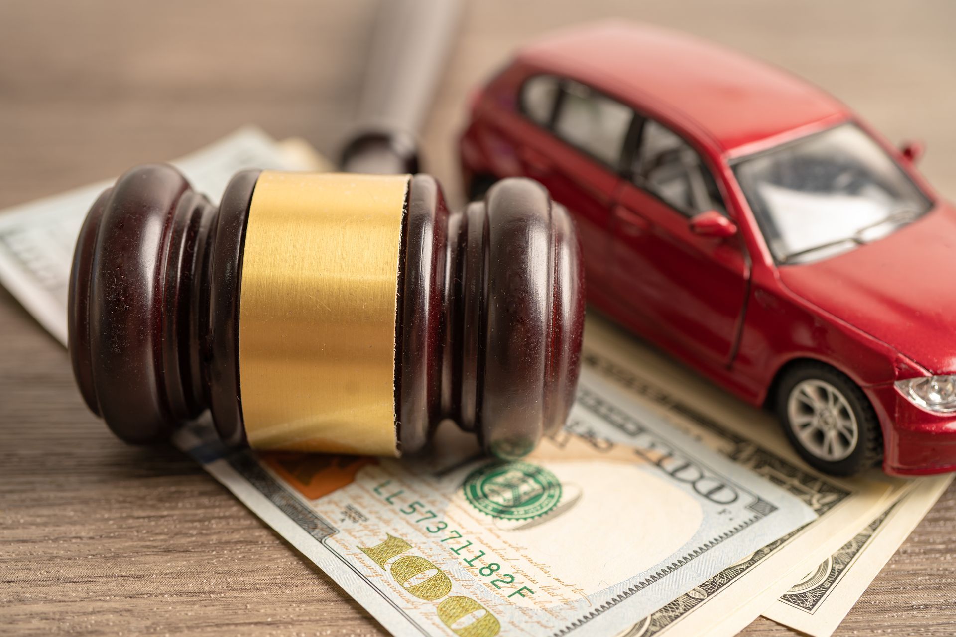 Car accident attorney concept with gavel, money, and vehicle model. Car accident attorney concept with gavel, money, and vehicle model.