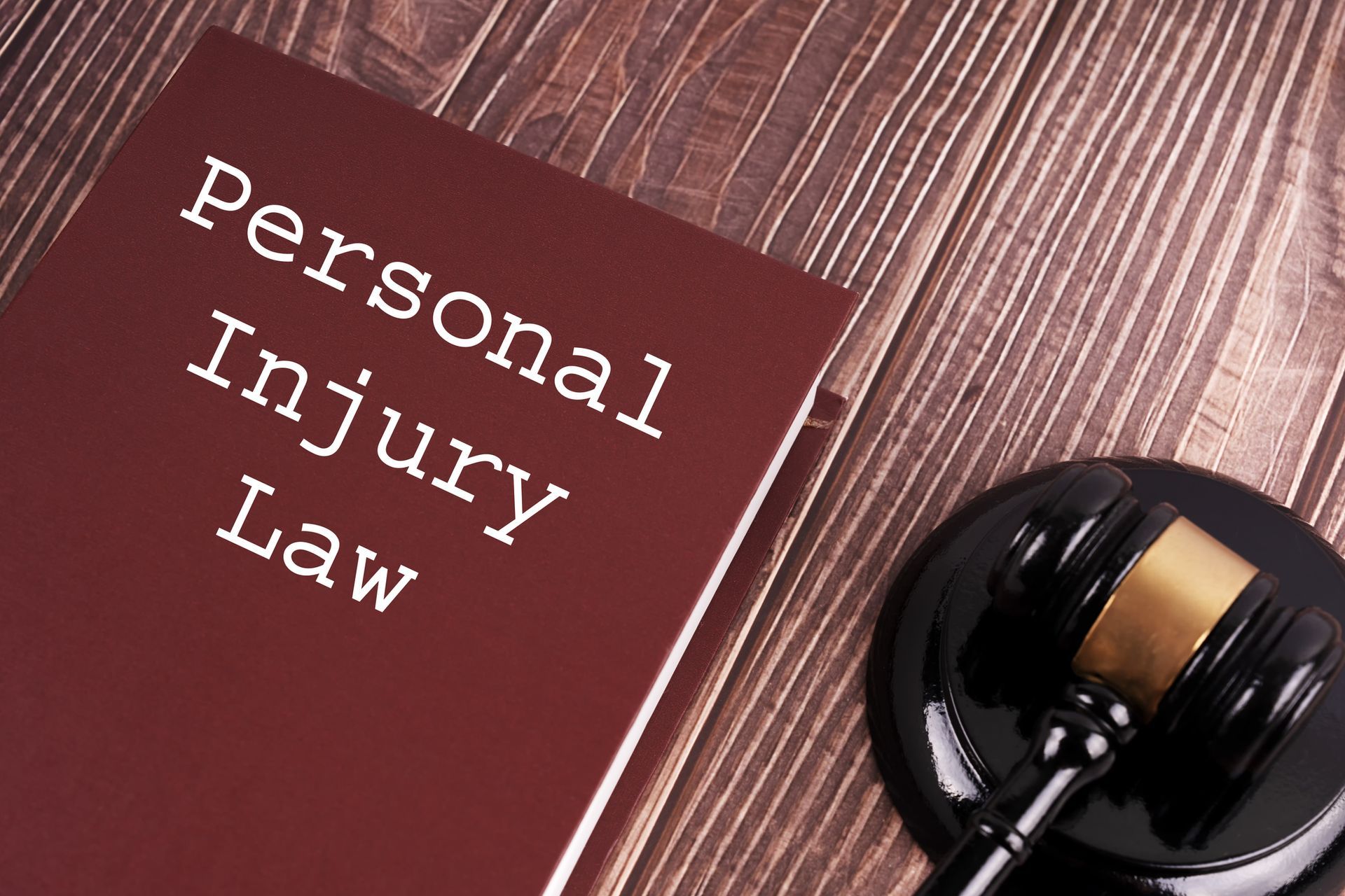 Personal Injury Attorneys book and judge gavel on table symbolizing legal representation.