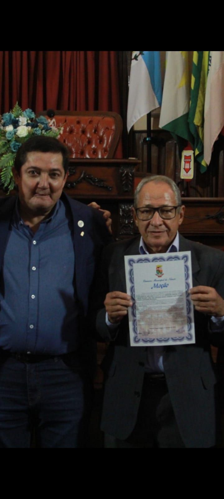 Dois homens estão de pé, um ao lado do outro, segurando um certificado.