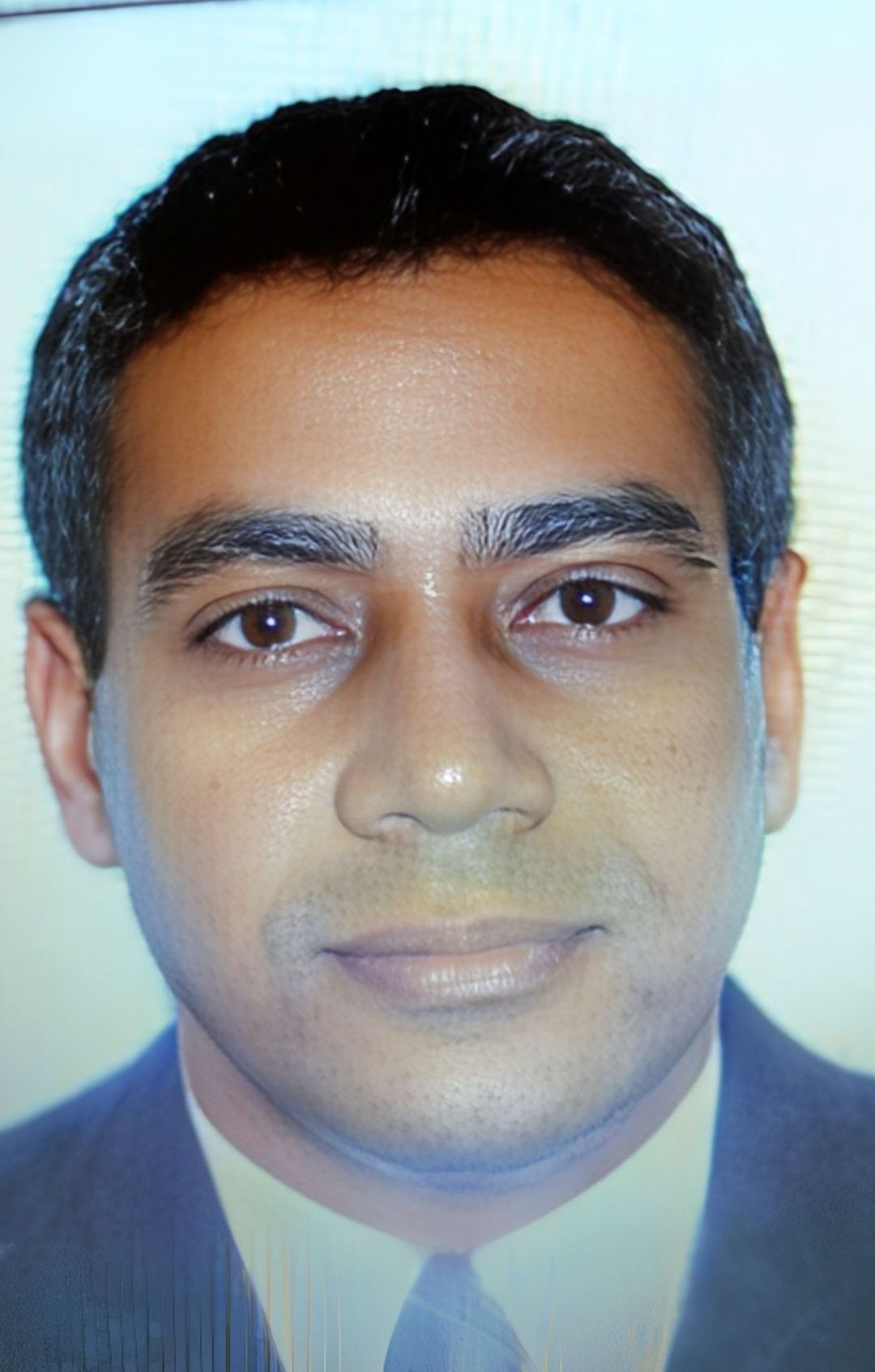 Um homem de terno e gravata está sorrindo para a câmera