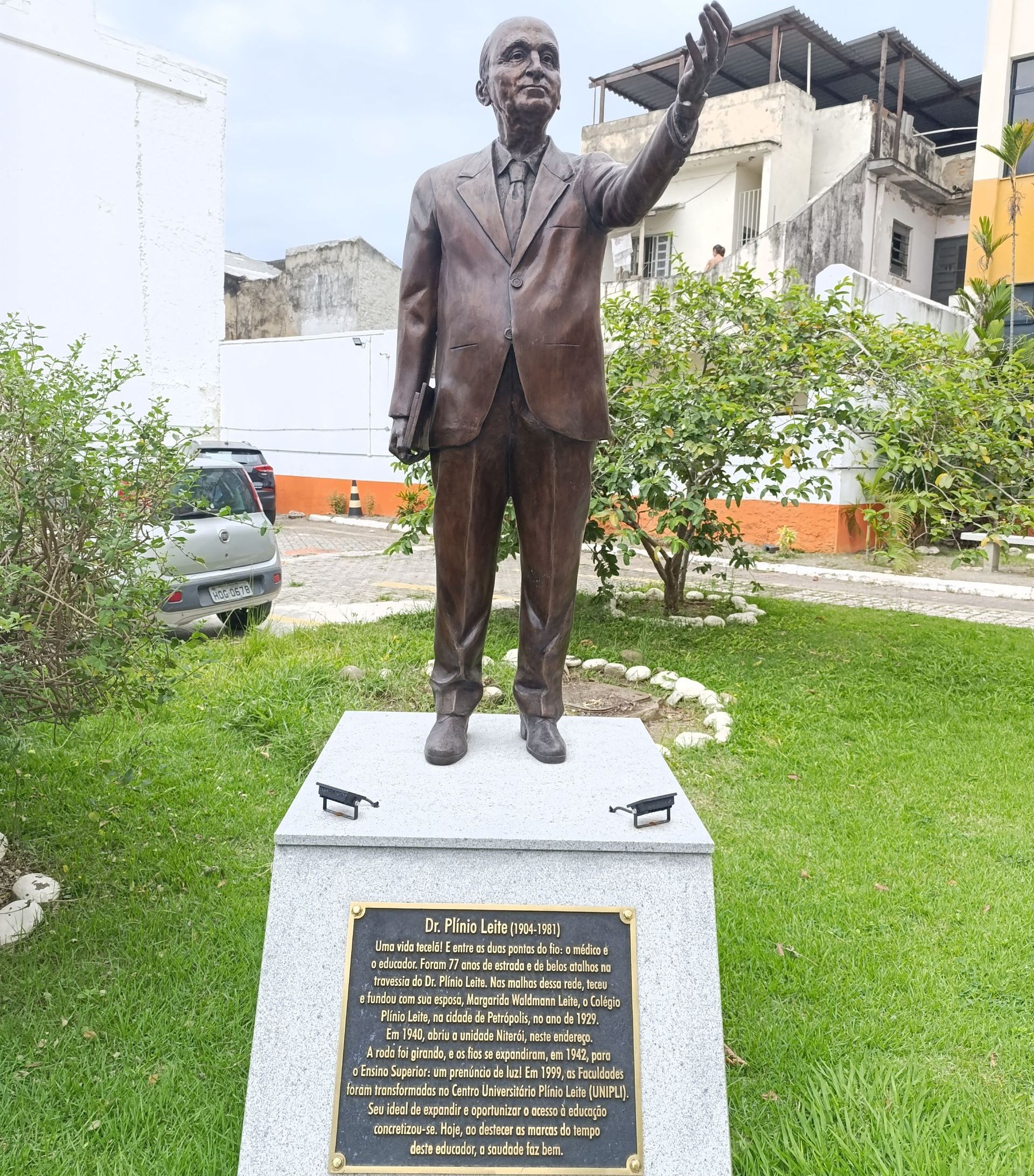 Uma estátua de um homem de terno está em um parque.