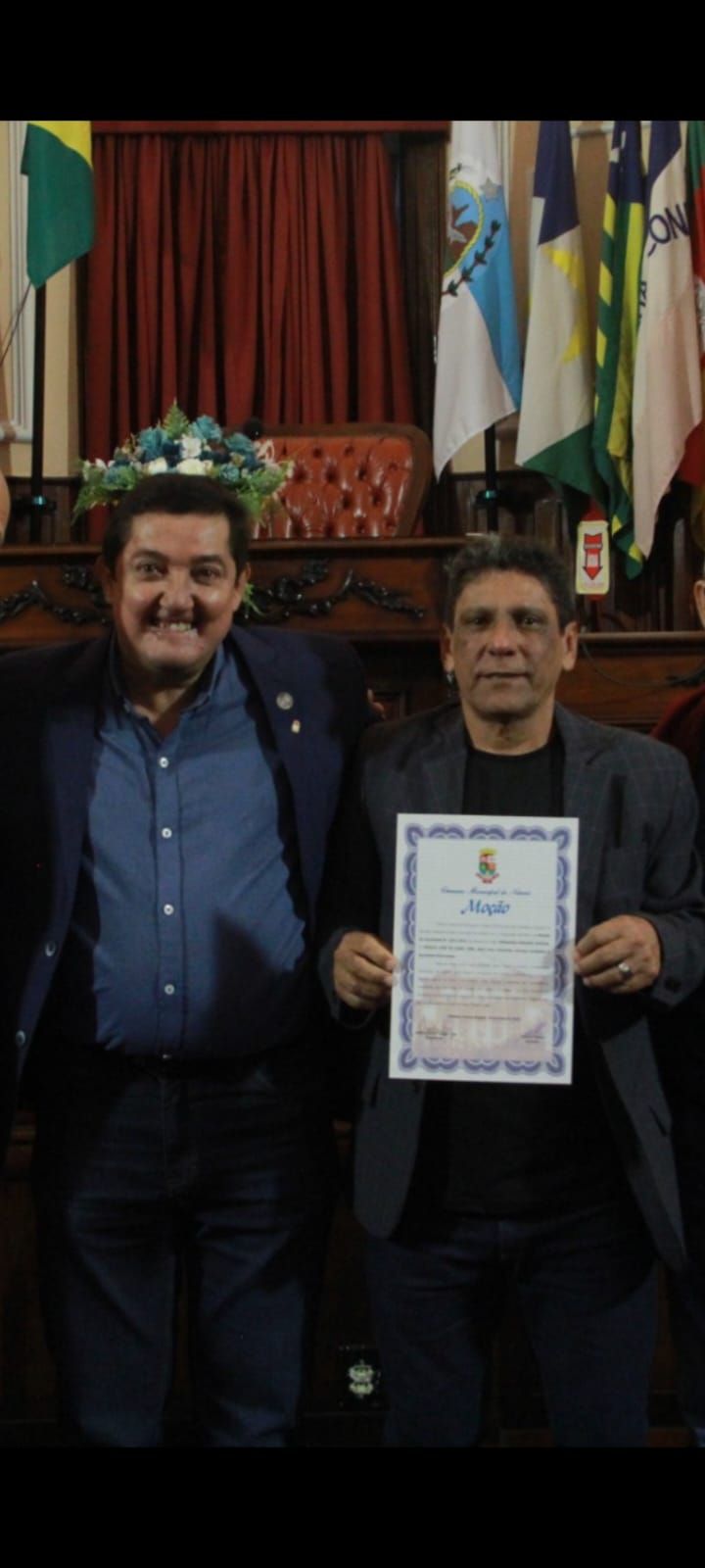 Dois homens estão de pé, um ao lado do outro, segurando um certificado.