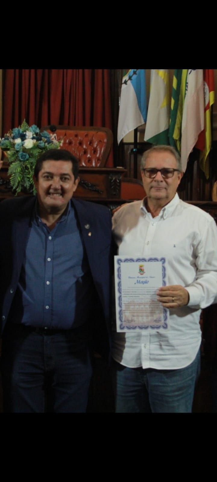 Dois homens estão de pé, um ao lado do outro, segurando um certificado.