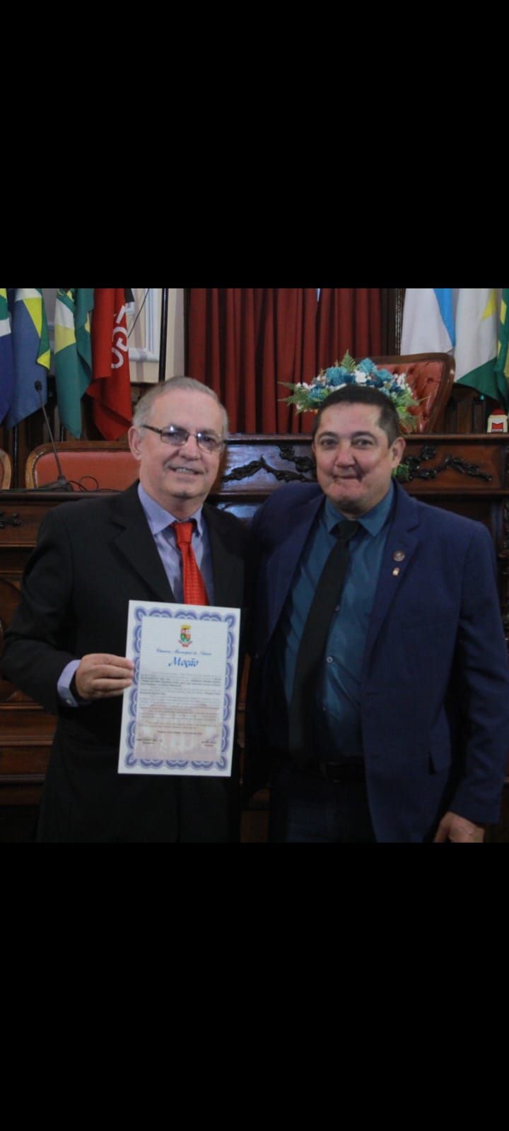 Dois homens estão de pé, um ao lado do outro, segurando um certificado.