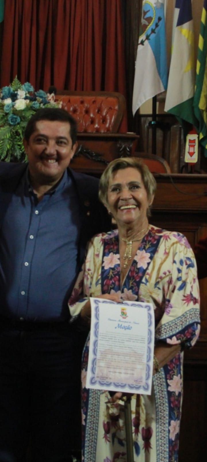 Um homem e uma mulher estão posando para uma foto e a mulher está segurando um certificado.