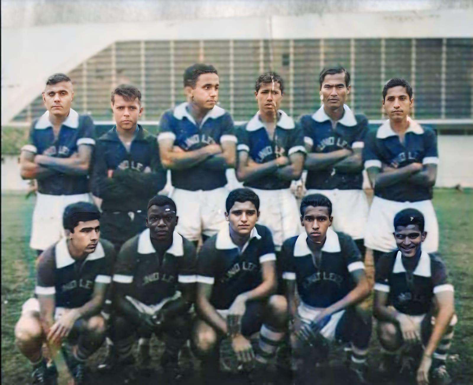 Um time de futebol posando para uma foto com os braços cruzados
