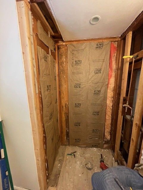 Bathroom remodel in progress; insulation installed between wood studs.