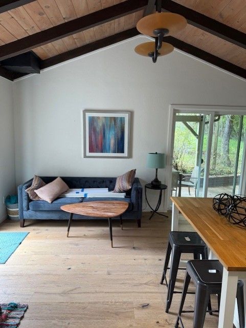 Living room with blue sofa, wooden coffee table, and ceiling fan; open to an outdoor patio.