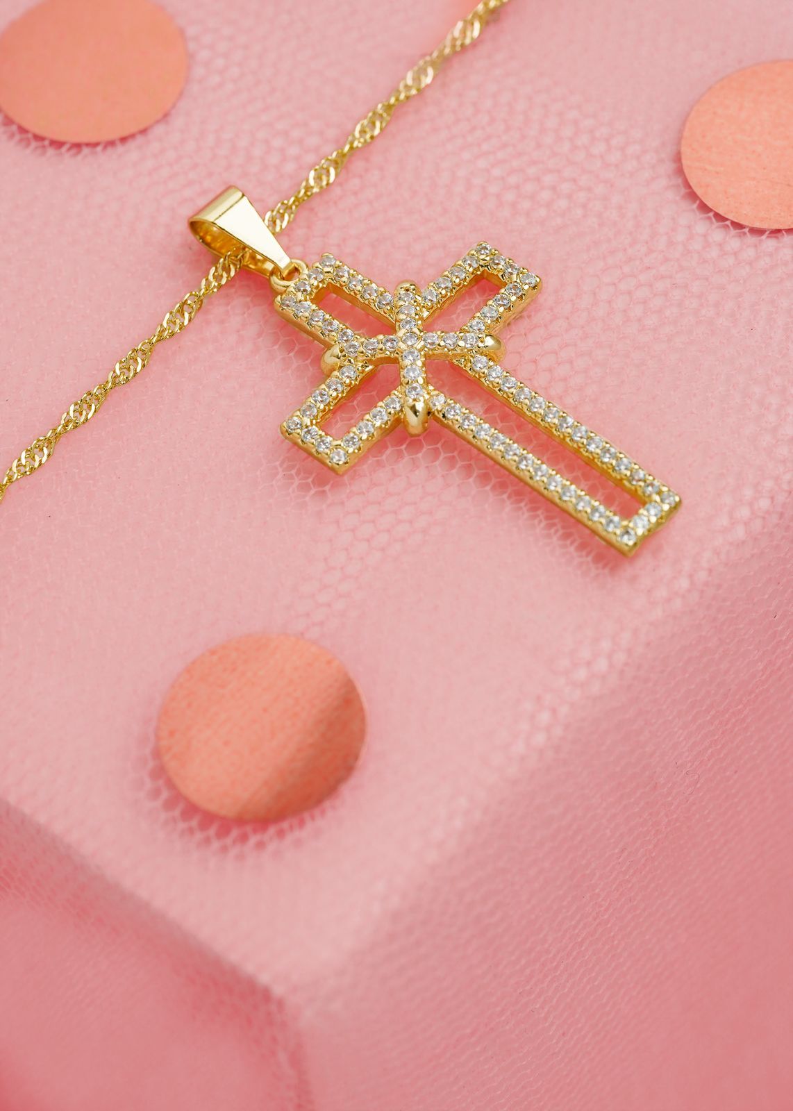 Un collar con colgante de cruz de oro que se lleva en una cadena pegada al pecho