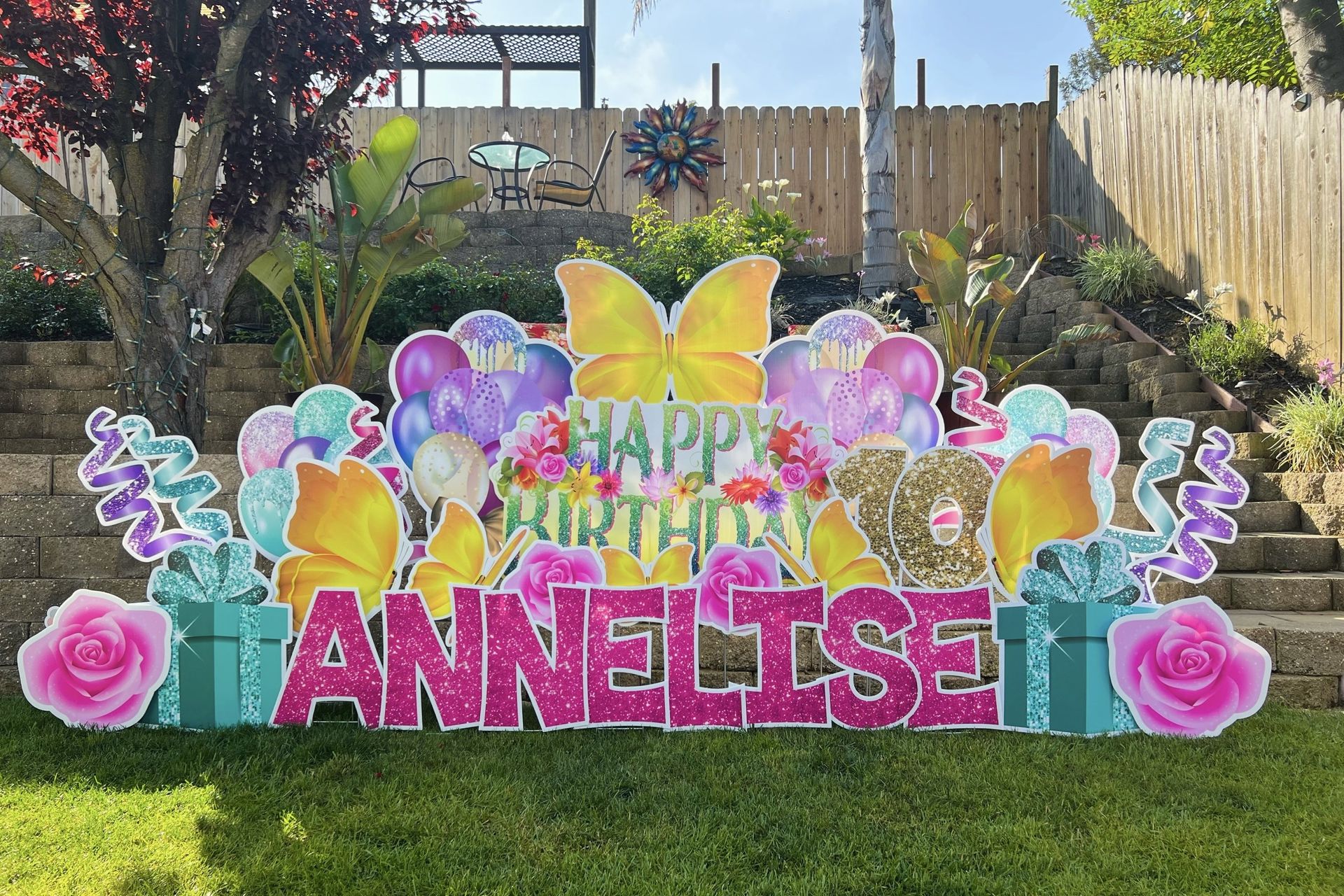 Birthday yard card in yellow, pink, purple, and teal colors. 