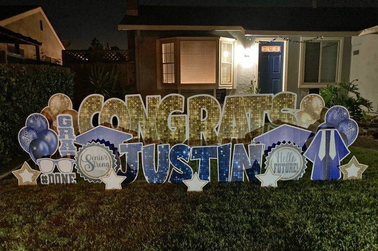 Graduation yard card in gold and blue. 