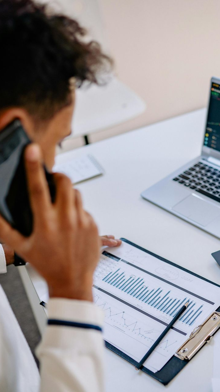 Personne au téléphone qui regarde son ordinateur