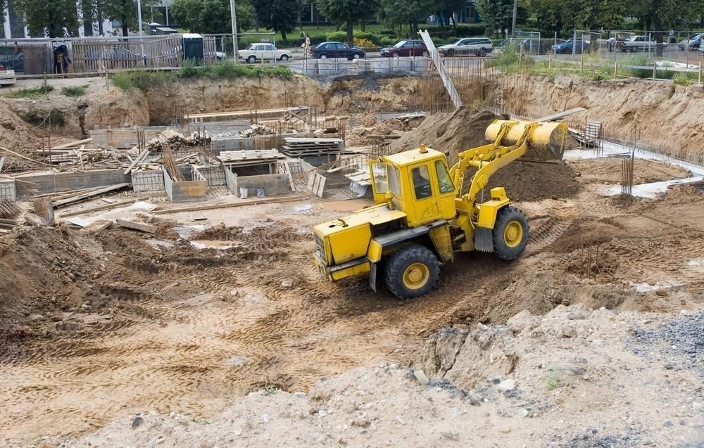 A yellow bulldozer is moving dirt on a construction site.