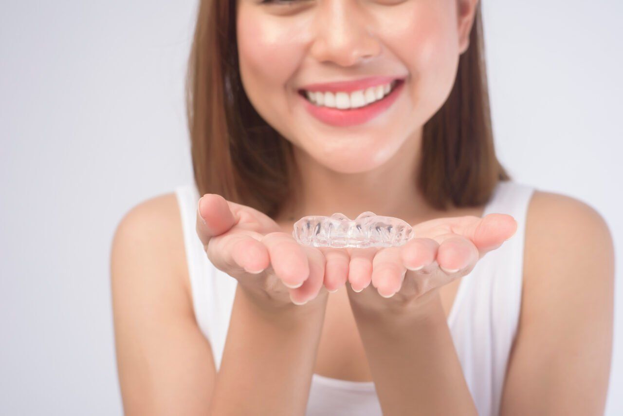 A woman is holding a clear brace in her hands.