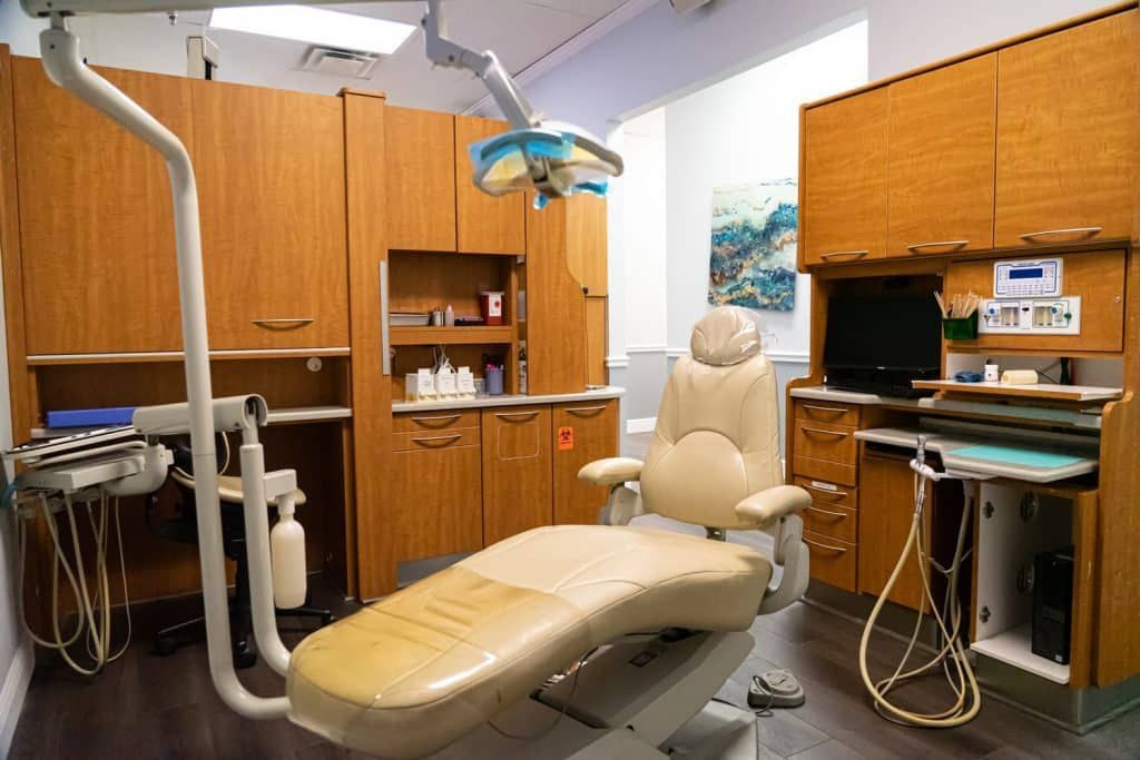 A dental office with a dental chair and a computer.