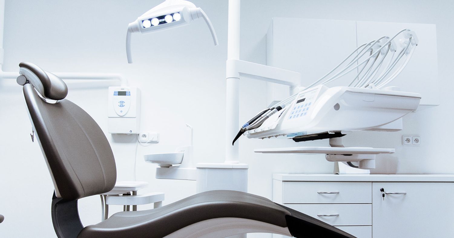 A dental chair is sitting in a dental office.